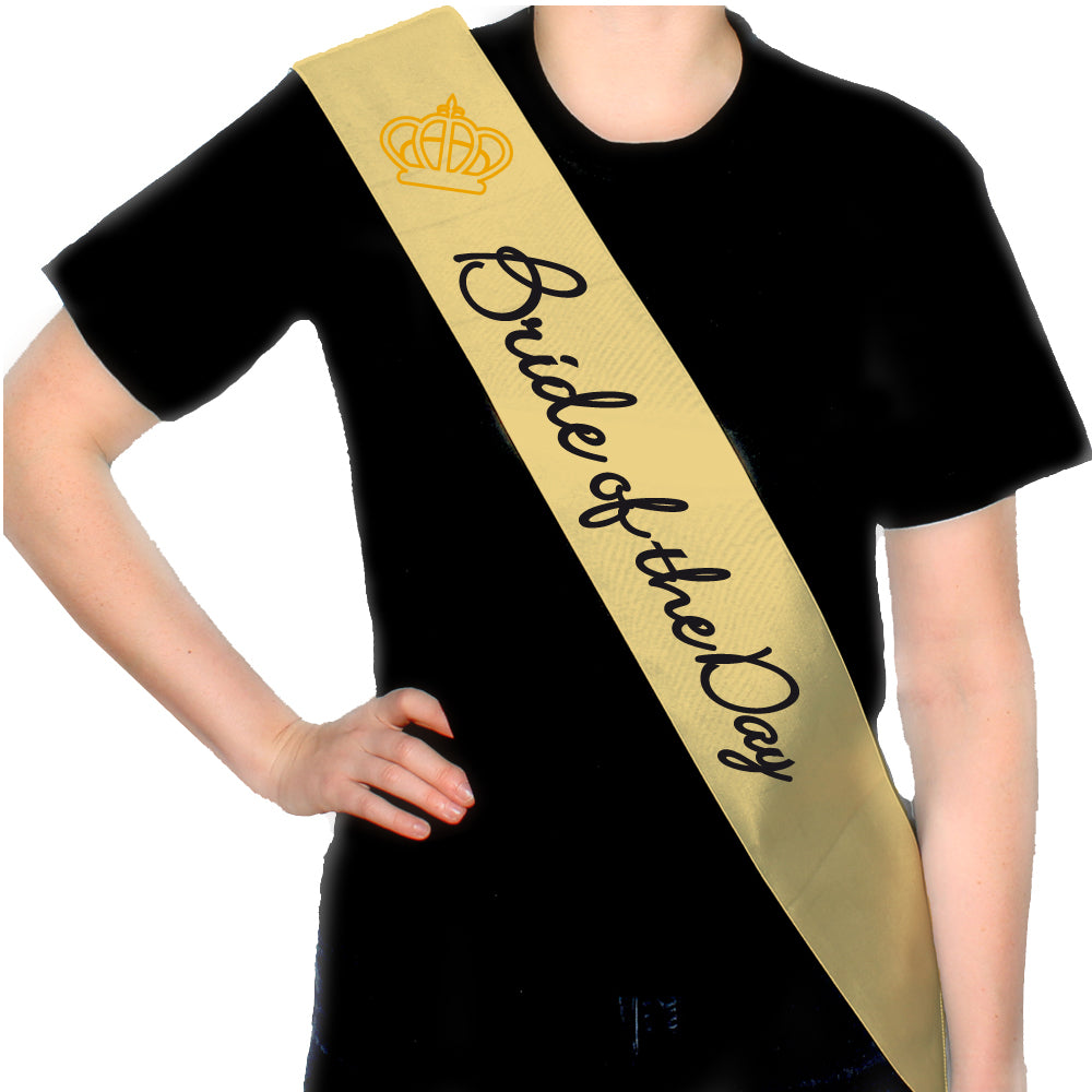 JGA Schärpe "Bride for a Day" in pink, weiß oder gold mit schwarzem Schriftzug "Bride of the day" in Schreibschrift und einer goldenen Krone darüber; aus fein gewebtem Polyester, glänzt im Licht, ideal für die Braut am Junggesellinnenabschied, praktisch zu tragen und gut zu verstauen.
