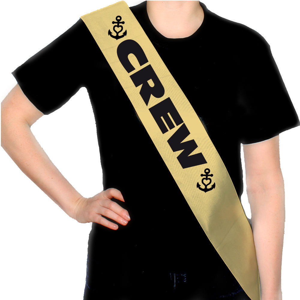JGA Schärpe "Anker Crew" in Weiß, Gold und Pink mit dem Schriftzug „CREW“; dekoriert mit Ankern und kleinen Herzen; aus 100% Polyester gefertigt; hat eine Gesamtlänge von 160 cm und eine Länge von 80 cm von der Taille bis zur Schulter; ideal für die Begleiterinnen der Braut beim Junggesellinnenabschied, passend zur Anker Braut Schärpe.