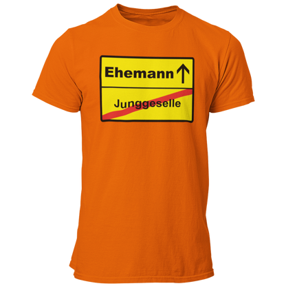 JGA T-Shirt mit dem Aufdruck 'JGA Ehemann Ortsschild' in auffälliger Farbe. Schlichtes, gerade geschnittenes Design für den Bräutigam, erhältlich in verschiedenen Farben und Größen.