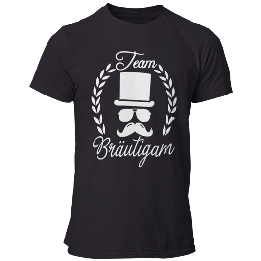 T-Shirt 'Team Bräutigam' mit schlichtem Design, ideal für die Crew des Bräutigams beim Junggesellenabschied. Das Shirt zeigt ein Logo mit einem Mann im Zylinder, Schnäuzer und Brille, umrahmt von einem Lorbeerkranz, der auf das bevorstehende Feiern hinweist. Obwohl das Design einfach gehalten ist, hebt es sich durch seine auffällige Darstellung hervor und macht die Gruppe sofort als Teil des Junggesellenabschieds erkennbar. Perfekt kombinierbar mit Hosenträgern oder einem Hut für einen festlichen Look