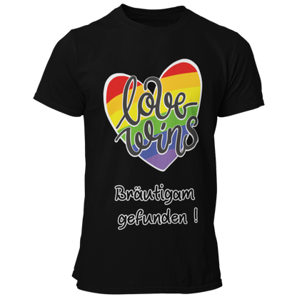  JGA-T-Shirt "Love wins" mit buntem Regenbogenherz und dem Schriftzug „Love wins – Bräutigam gefunden!“. Ideal für den schwulen Junggesellenabschied, um stolz auf die Liebe und die bevorstehende Hochzeit hinzuweisen. Erhältlich in verschiedenen Farben für einen festlichen Regenbogenlook.