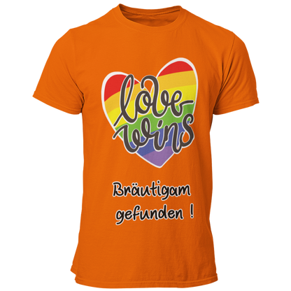  JGA-T-Shirt "Love wins" mit buntem Regenbogenherz und dem Schriftzug „Love wins – Bräutigam gefunden!“. Ideal für den schwulen Junggesellenabschied, um stolz auf die Liebe und die bevorstehende Hochzeit hinzuweisen. Erhältlich in verschiedenen Farben für einen festlichen Regenbogenlook.