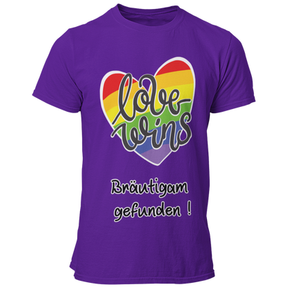  JGA-T-Shirt "Love wins" mit buntem Regenbogenherz und dem Schriftzug „Love wins – Bräutigam gefunden!“. Ideal für den schwulen Junggesellenabschied, um stolz auf die Liebe und die bevorstehende Hochzeit hinzuweisen. Erhältlich in verschiedenen Farben für einen festlichen Regenbogenlook.