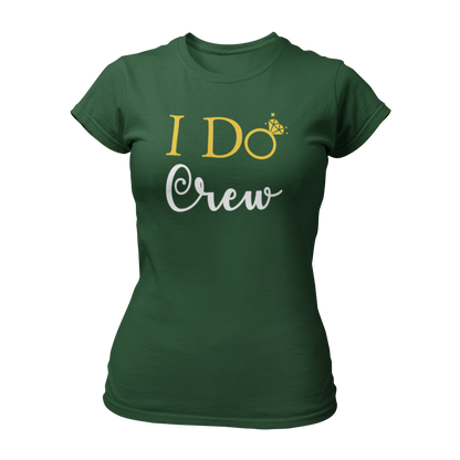 Damen T-Shirt "I do Crew" mit feinem Design und dem Text „I Do Crew“, das für die Begleiterinnen der Braut entworfen wurde. Der Schriftzug zeigt ein „o“ in Form eines Eherings mit Brillant, symbolisiert die bevorstehende Hochzeit und ist in Gold, Schwarz oder Weiß gehalten. Das körperbetonte Shirt hat kurze Ärmel und einen runden Ausschnitt, ideal für einen unvergesslichen Junggesellinnenabschied.