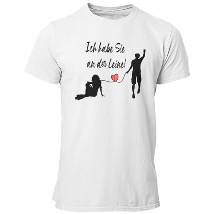 JGA-T-Shirt "Ich habe Sie an der Leine" für den Bräutigam mit stilisiertem Brautpaar und rotem Herz. Humorvolles Design, das stilvoll und witzig ist, ideal für den Junggesellenabschied. Passend für Freunde und Begleiter des Junggesellen.