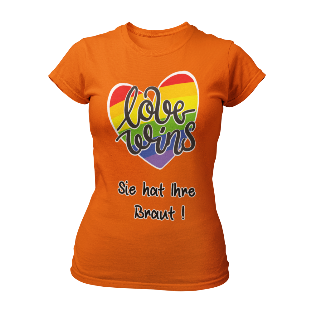 Damen T-Shirt "Love wins! Sie hat Ihre Braut!" im Regenbogen-Look, mit verspieltem Schriftzug „love wins“ auf einem herzförmigen Hintergrund. Das Shirt feiert die gleichgeschlechtliche Ehe und betont mit dem zusätzlichen Slogan „Sie hat ihre Braut!“, dass hier zwei Frauen heiraten. Hergestellt aus hochwertigem Material mit Doppelnähten, ist es ein ideales, figurbetontes JGA-Shirt für einen bunten und offenen Junggesellinnenabschied.