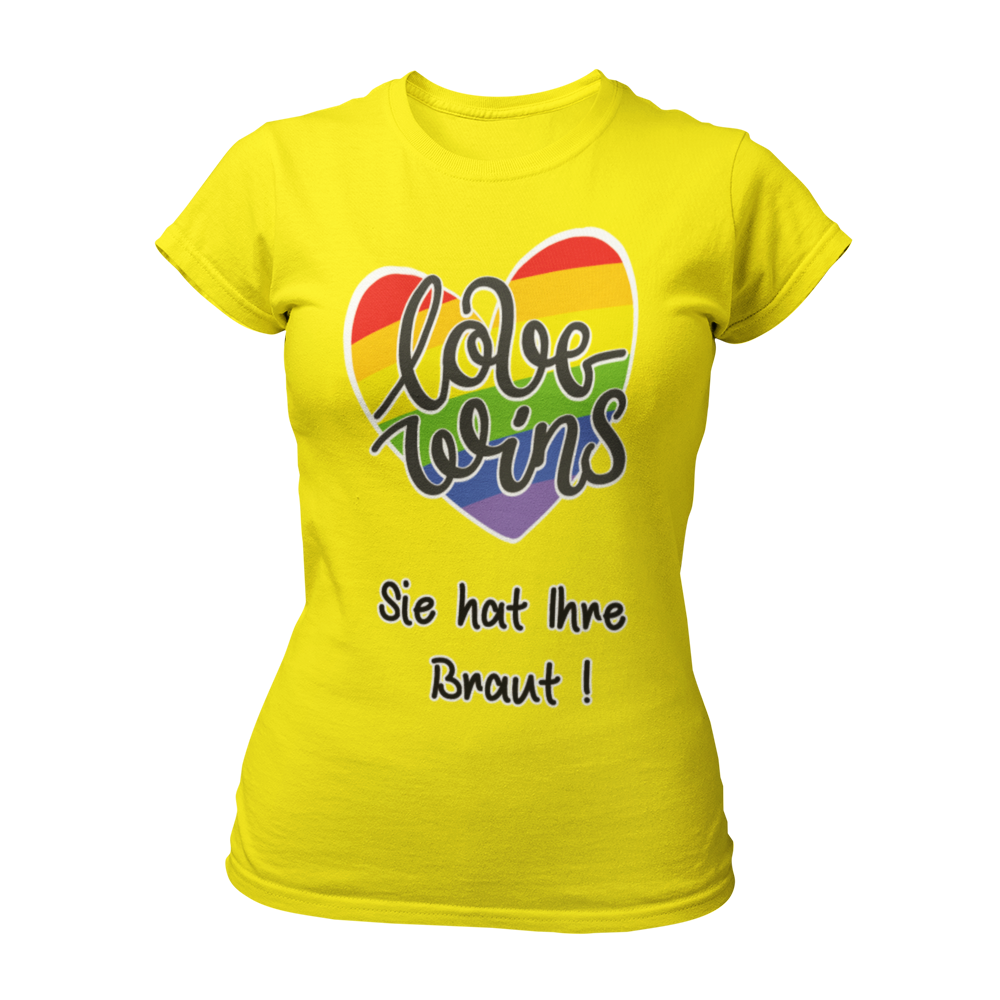 Damen T-Shirt "Love wins! Sie hat Ihre Braut!" im Regenbogen-Look, mit verspieltem Schriftzug „love wins“ auf einem herzförmigen Hintergrund. Das Shirt feiert die gleichgeschlechtliche Ehe und betont mit dem zusätzlichen Slogan „Sie hat ihre Braut!“, dass hier zwei Frauen heiraten. Hergestellt aus hochwertigem Material mit Doppelnähten, ist es ein ideales, figurbetontes JGA-Shirt für einen bunten und offenen Junggesellinnenabschied.