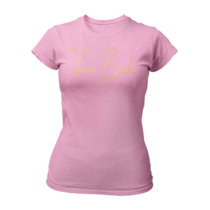 Damen T-Shirt "Team Bride Glamour" mit glitzerndem Gold-Druck in geschnörkelten Buchstaben. Ideal für einen Junggesellinnenabend unter dem Motto „Glitzer & Glamour“, verbindet es Stil und Qualität zu einem erschwinglichen Preis. Perfekt für die Braut und ihre Begleiterinnen, um den besonderen Anlass gebührend zu feiern.