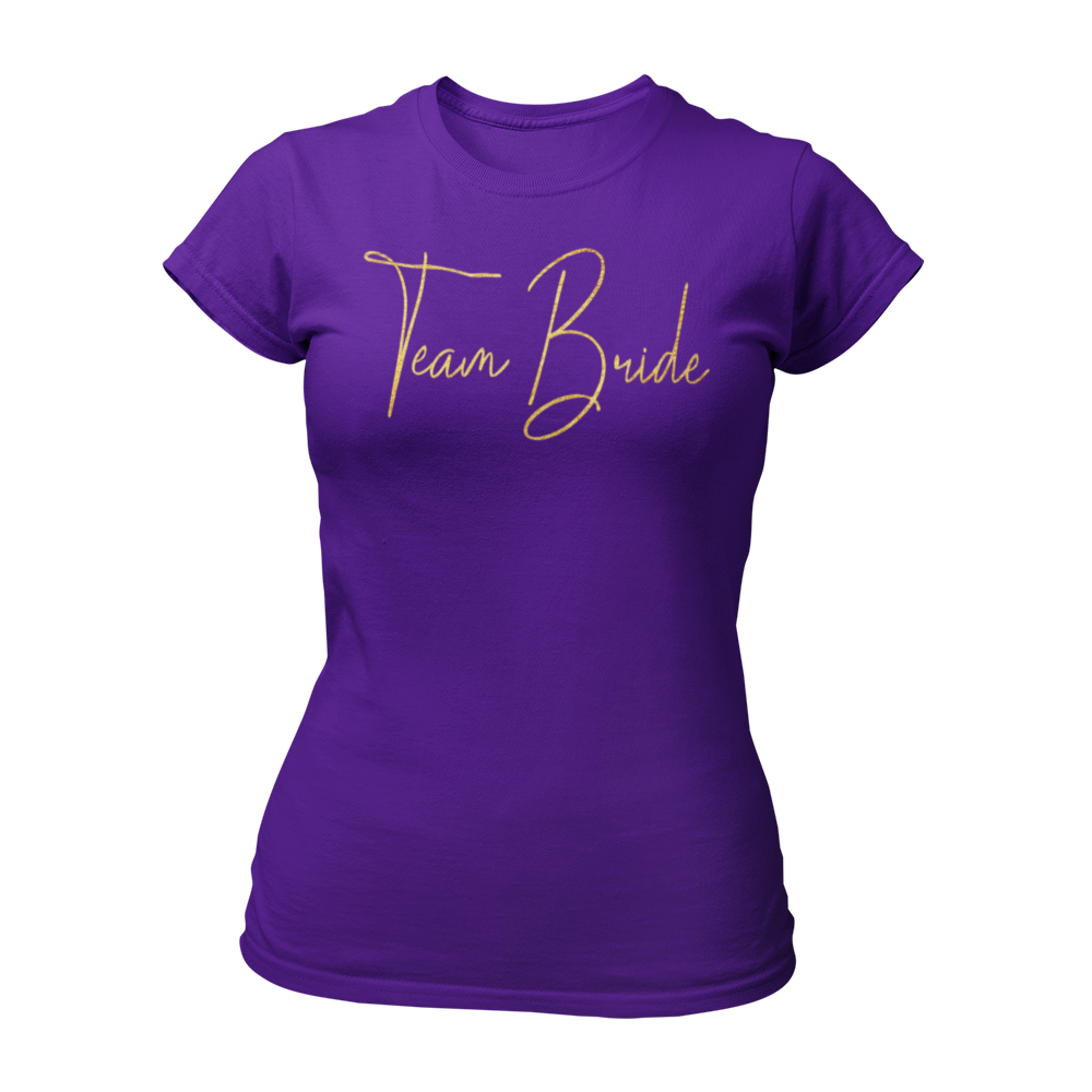 Damen T-Shirt "Team Bride Glamour" mit glitzerndem Gold-Druck in geschnörkelten Buchstaben. Ideal für einen Junggesellinnenabend unter dem Motto „Glitzer & Glamour“, verbindet es Stil und Qualität zu einem erschwinglichen Preis. Perfekt für die Braut und ihre Begleiterinnen, um den besonderen Anlass gebührend zu feiern.