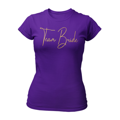 Damen T-Shirt "Team Bride Glamour" mit glitzerndem Gold-Druck in geschnörkelten Buchstaben. Ideal für einen Junggesellinnenabend unter dem Motto „Glitzer & Glamour“, verbindet es Stil und Qualität zu einem erschwinglichen Preis. Perfekt für die Braut und ihre Begleiterinnen, um den besonderen Anlass gebührend zu feiern.