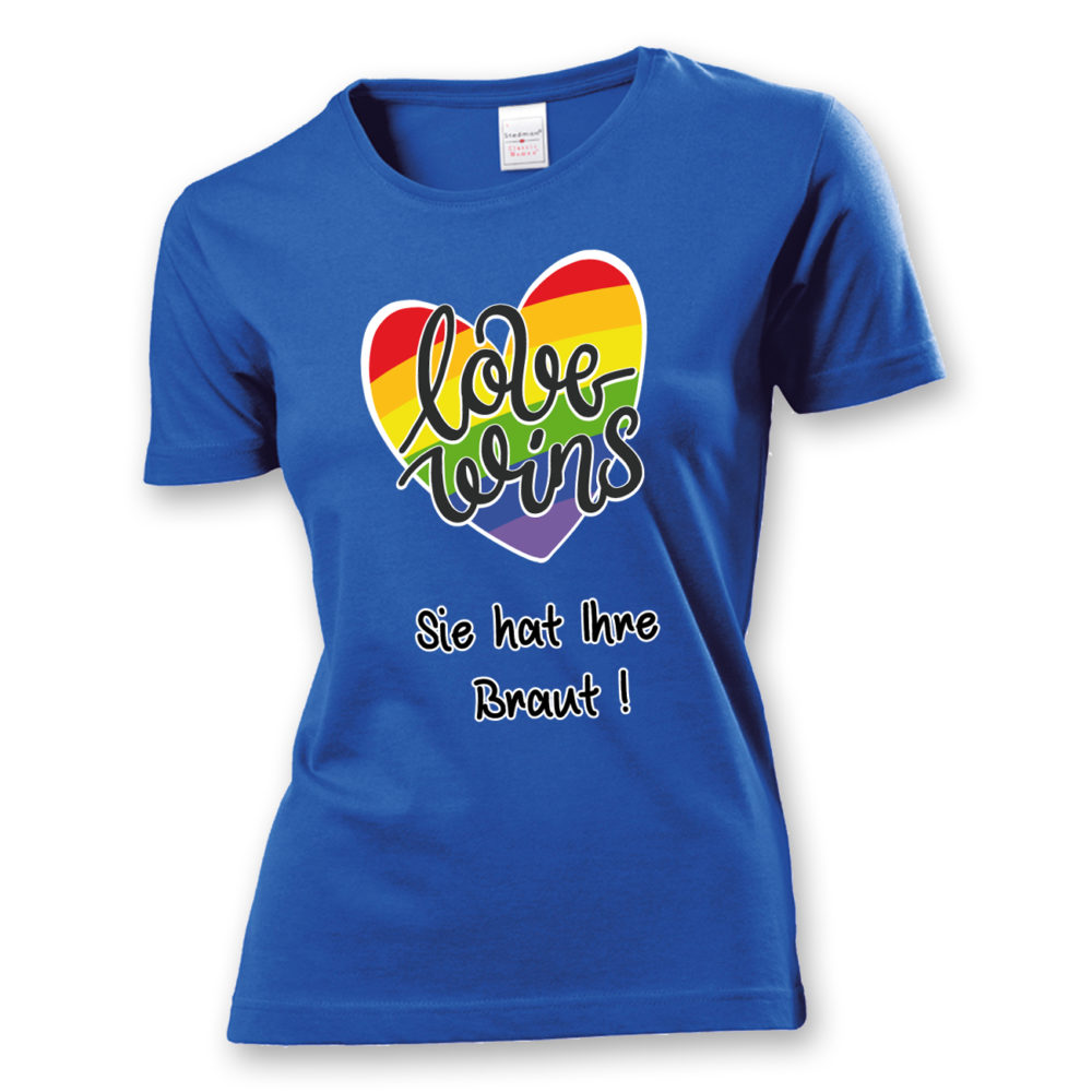 Damen T-Shirt "Love wins! Sie hat Ihre Braut!" im Regenbogen-Look, mit verspieltem Schriftzug „love wins“ auf einem herzförmigen Hintergrund. Das Shirt feiert die gleichgeschlechtliche Ehe und betont mit dem zusätzlichen Slogan „Sie hat ihre Braut!“, dass hier zwei Frauen heiraten. Hergestellt aus hochwertigem Material mit Doppelnähten, ist es ein ideales, figurbetontes JGA-Shirt für einen bunten und offenen Junggesellinnenabschied.